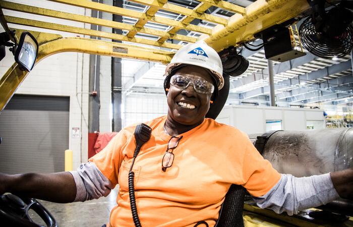 A female paper and wood products employee smiling brightly.